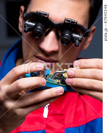 Computer specialist repairing PC late at night 67645548