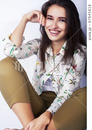young pretty brunette girl hipster posing frendly against white background wall, smiling woman with long hair young pretty brunette girl hipster posing frendly against white background wall, smiling woman with long hair 67645818