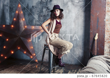 young pretty woman waiting alone in modern loft studio, fashion clothers wearing hat, lifestyle and people home concept young pretty woman waiting alone in modern loft studio, fashion clothers wearing hat, lifestyle and people home concept 67645820