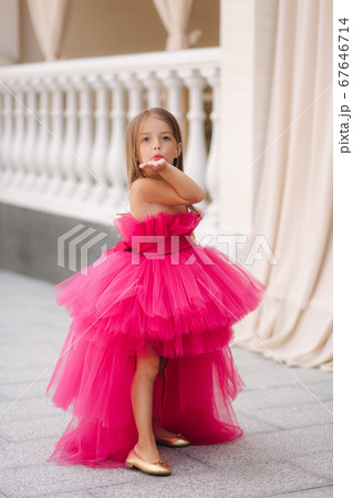 Beautiful little girl in pink fluffy dress give an air kiss Beautiful little girl in pink fluffy dress give an air kiss 67646714
