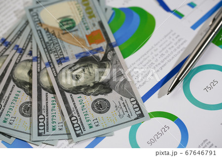 American banknotes lying on economic papers on table 67646791