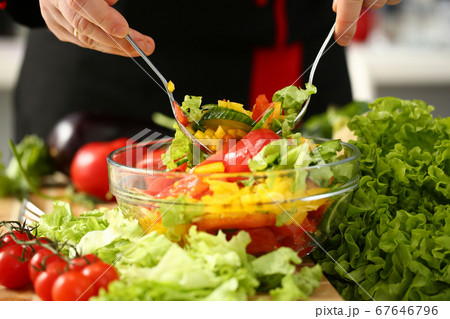 Man preparing fresh vegetarian salad in kitchen 67646796