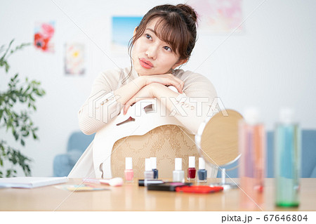 自宅のリビングでカメラ目線で微笑む若い女性のポートレート 自宅のリビングでカメラ目線で微笑む若い女性のポートレート 67646804