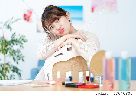 自宅のリビングでカメラ目線で微笑む若い女性のポートレート 自宅のリビングでカメラ目線で微笑む若い女性のポートレート 67646806