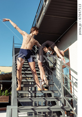 Couple of modern ballet dancers performing on the stairs at the city Couple of modern ballet dancers performing on the stairs at the city 67647513