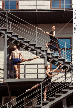 The group of modern ballet dancers performing on the stairs at the city 67647592