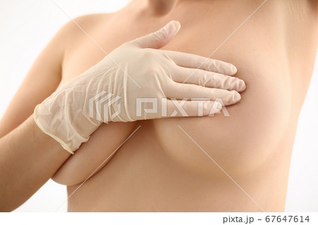 Female examining her breast for avoiding cancer Female examining her breast for avoiding cancer 67647614