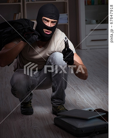 Burglar wearing balaclava mask at crime scene Burglar wearing balaclava mask at crime scene 67647918