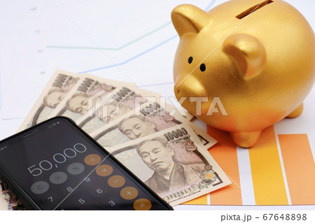貯金箱とグラフとスマホの電卓アプリ 67648898