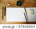 Workplace with paper, paintbrushes, pencils on a wooden table. Mockup for lettering and drawing. Top view. 67648904