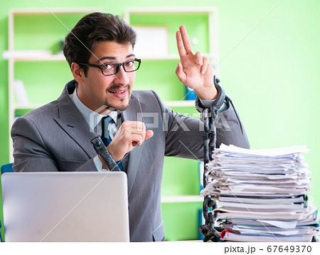 Employee chained to his desk due to workload Employee chained to his desk due to workload 67649370