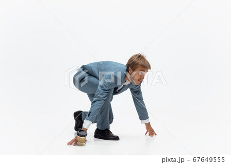 Man in office clothes running, jogging on white background. Unusual look for businessman in motion, action. Sport, healthy lifestyle. Man in office clothes running, jogging on white background. Unusual look for businessman in motion, action. Sport, healthy lifestyle. 67649555