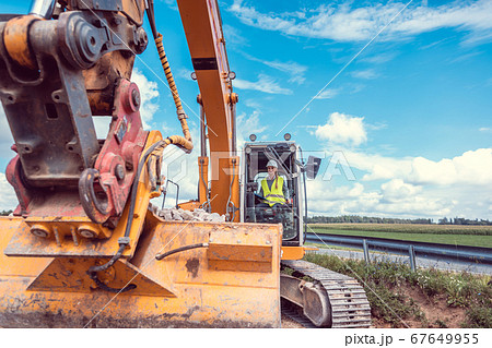 Woman construction worker with excavator on sit 67649955