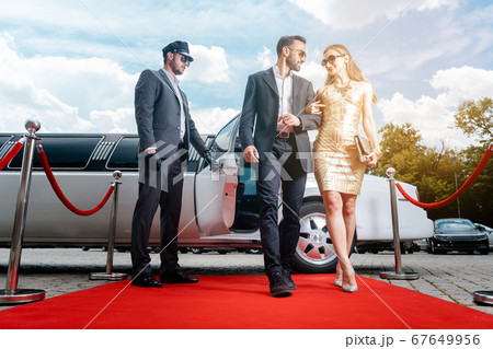 Couple arriving with limousine walking red carpet 67649956