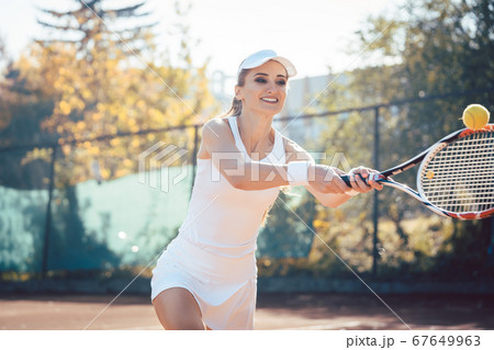 Woman playing tennis on court Woman playing tennis on court 67649963