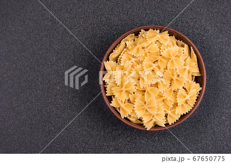 Farfalle or Bow Tie Pasta in bowl on gray Farfalle or Bow Tie Pasta in bowl on gray 67650775