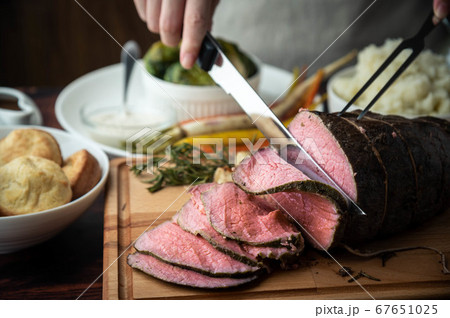 carving roast beef with knife and fork 67651025