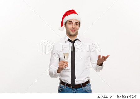 Christmas Concept - Handsome Business man celebrate merry christmas and happy new year wear santa hat with glass of champange. 67653414