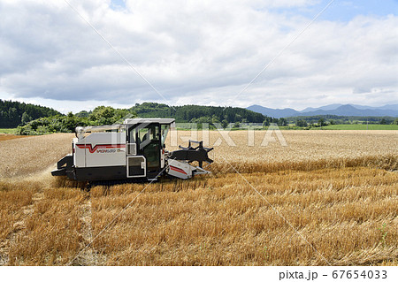 北海道厚沢部町で麦秋を迎えコンバインで麦の刈り入れ作業をする夏の風景を撮影 北海道厚沢部町で麦秋を迎えコンバインで麦の刈り入れ作業をする夏の風景を撮影 67654033