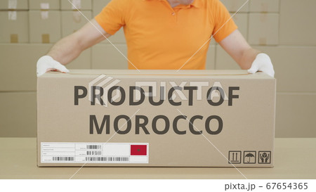 Warehouse worker and big box with PRODUCT OF MOROCCO printed text 67654365