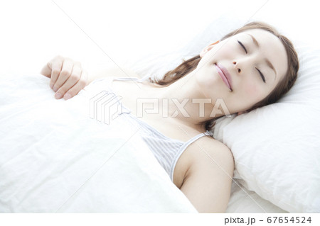 ベッドで眠る女性 67654524