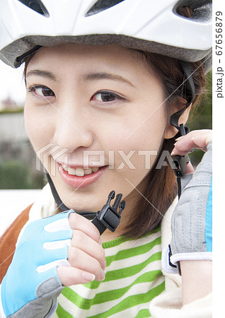 サイクリングヘルメットを被る女性 67656879
