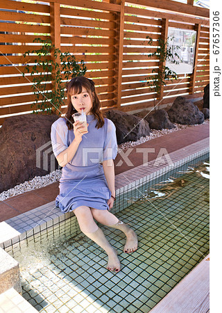 足湯に入浴中の若い女性 67657306