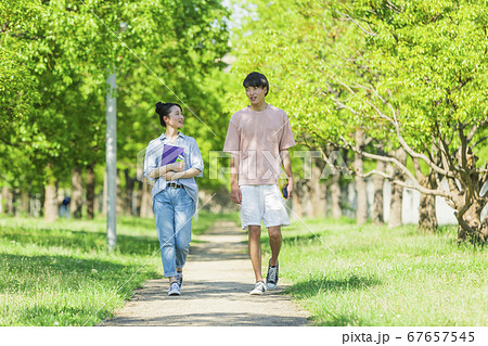 会話をしながら歩く若者2人組 67657545