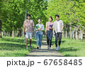 会話をしながら歩く若者2人組 67658485