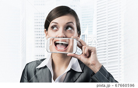 Woman covering her mouth with smartphone 67660596