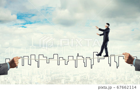 Business concept of risk support and assistance with man balancing on rope 67662114