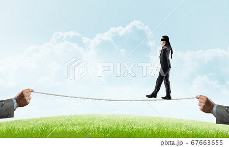 Business concept of risk support and assistance with man balancing on rope 67663655