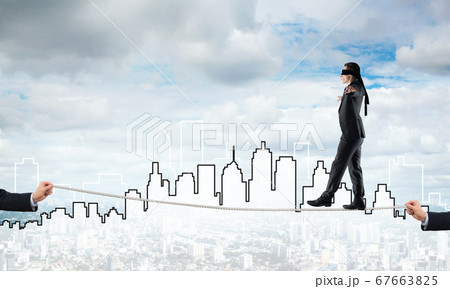 Business concept of risk support and assistance with man balancing on rope 67663825