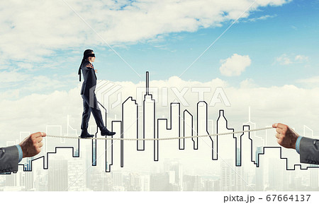 Business concept of risk support and assistance with man balancing on rope 67664137