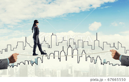 Business concept of risk support and assistance with man balancing on rope 67665550