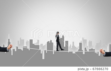 Business concept of risk support and assistance with man balancing on rope 67666270