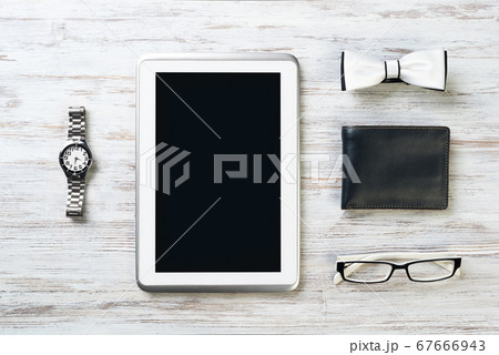 Gentleman kit of tablet watch glasses bow tie and notebook on wooden table Gentleman kit of tablet watch glasses bow tie and notebook on wooden table 67666943
