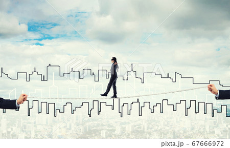 Business concept of risk support and assistance with man balancing on rope 67666972