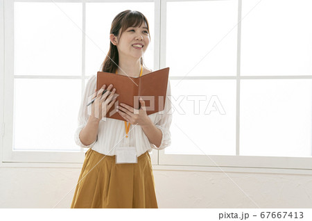 窓際で皮の手帳を見る若い女性 窓際で皮の手帳を見る若い女性 67667413