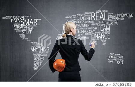 Businesswoman standing near world map on wall 67668209