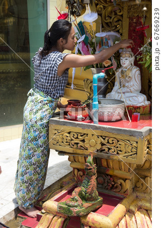 woman sprinkling water statue of Buddha woman sprinkling water statue of Buddha 67669239