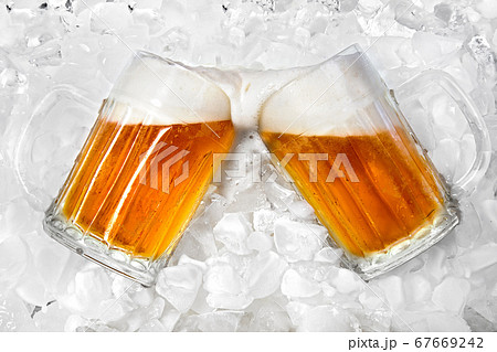 Glass of cold beer lying in the ice Glass of cold beer lying in the ice 67669242