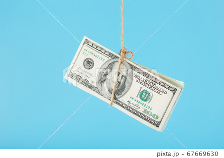 Dollars are tied on a rope, on a blue background. Dollars are tied on a rope, on a blue background. 67669630