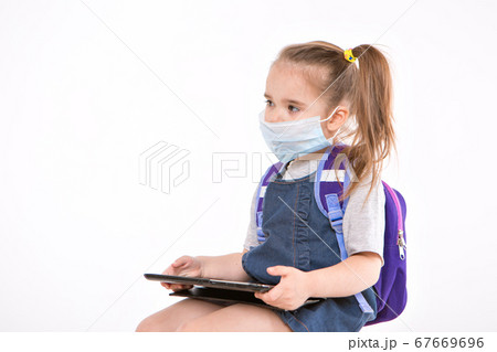 1 September. first-grader in medical school is going to school. little girl on home distance learning. child with backpack is working on laptop. student is doing homework. isolated on white background 67669696