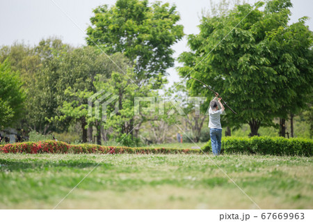芝生の上で一人で遊んでいる子ども 67669963