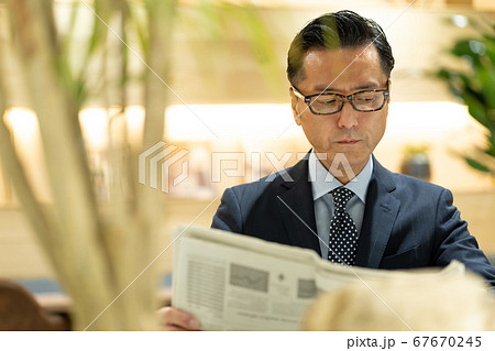 新聞を読むビジネスマンの写真素材