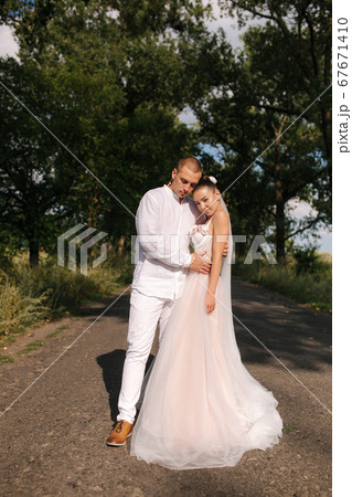 Goom and bride walkin in the park in wedding day. Summmer wedding Goom and bride walkin in the park in wedding day. Summmer wedding 67671410