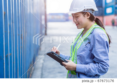 Woman staff worker happy working in shipping logistic cargo load area use tablet wireless technology 67673176