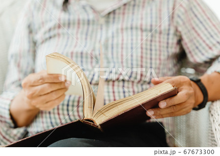 Closeup elder hand opening reading a book 67673300