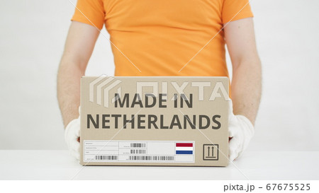 Parcel with MADE IN NETHERLANDS text and warehouse worker 67675525